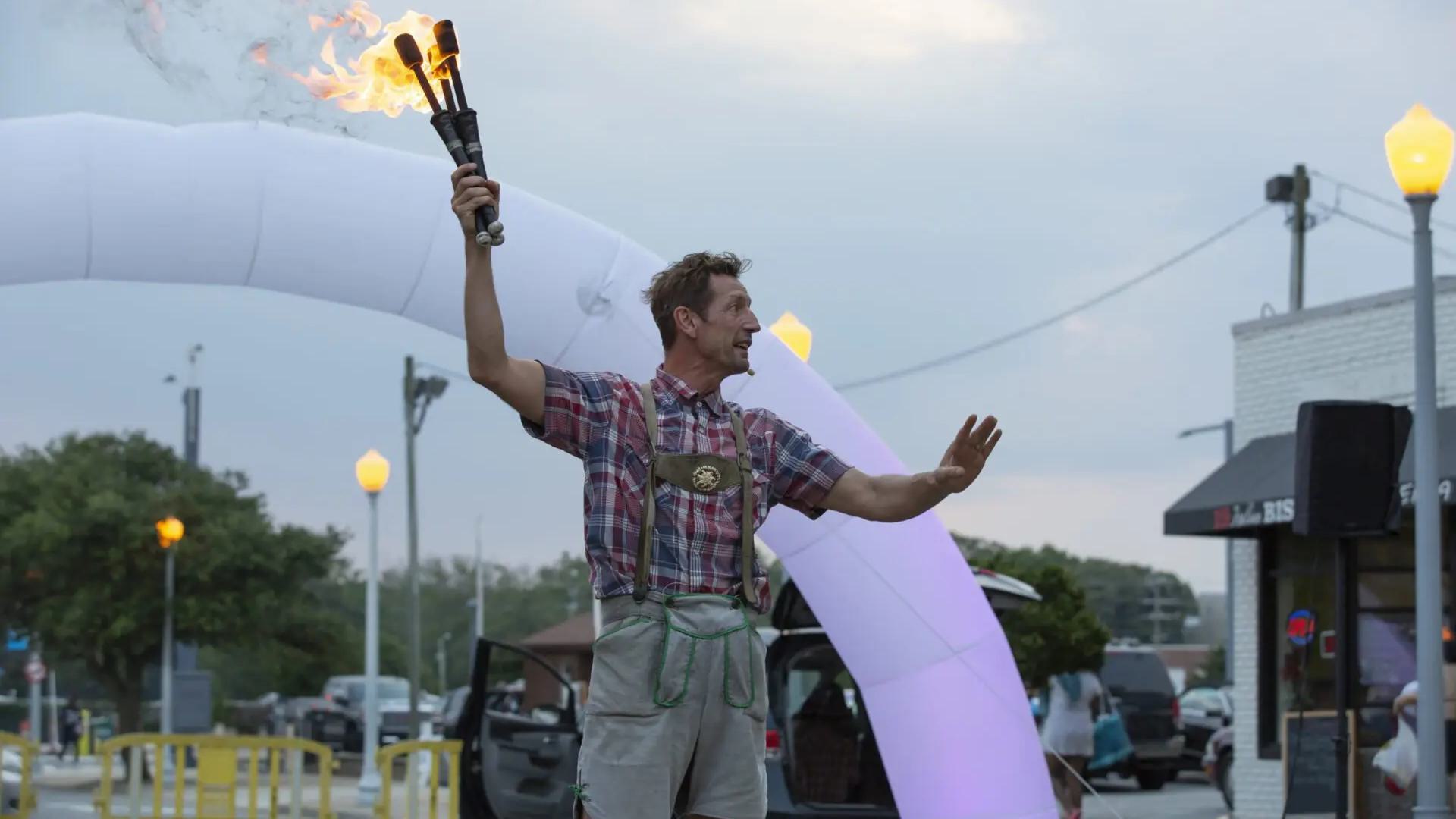 a photo of a man holding a torch with an arch behind him