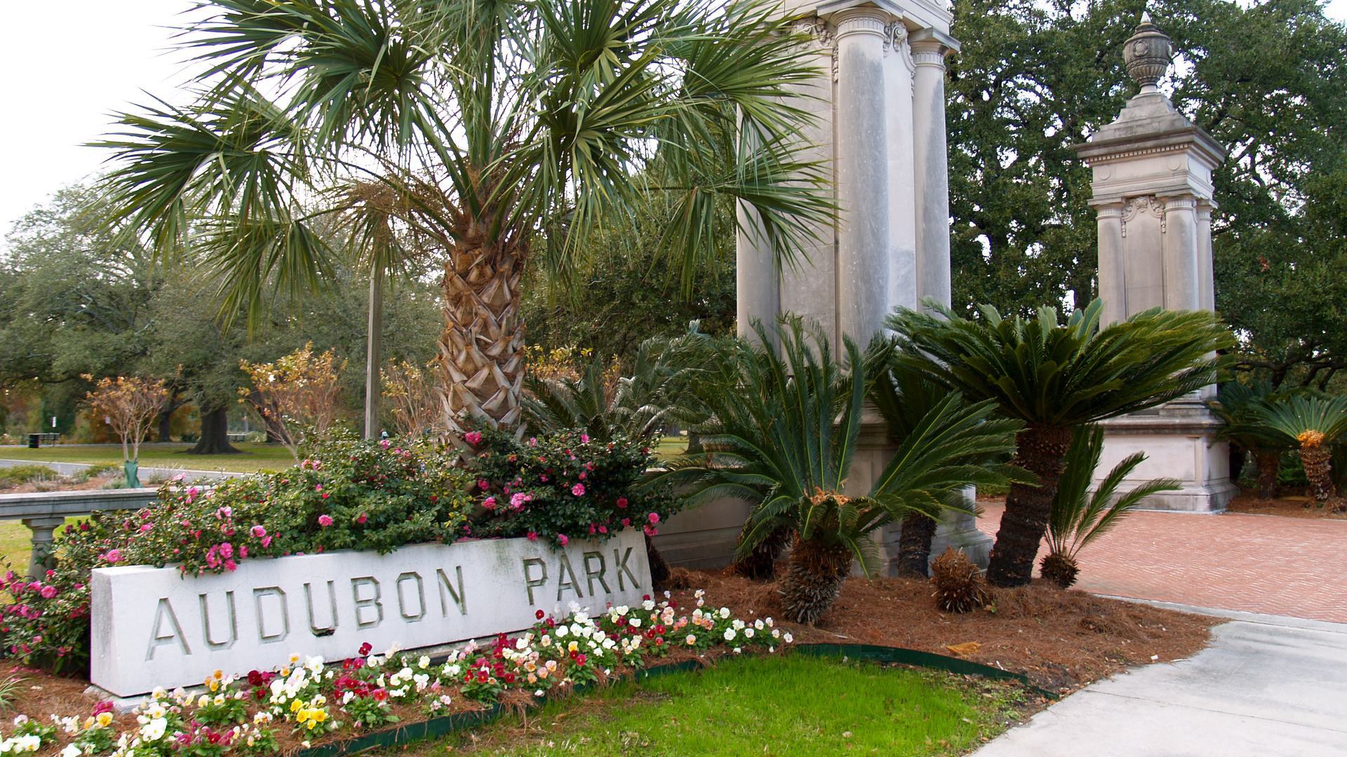 entrance to audubon park with two pillars and tress