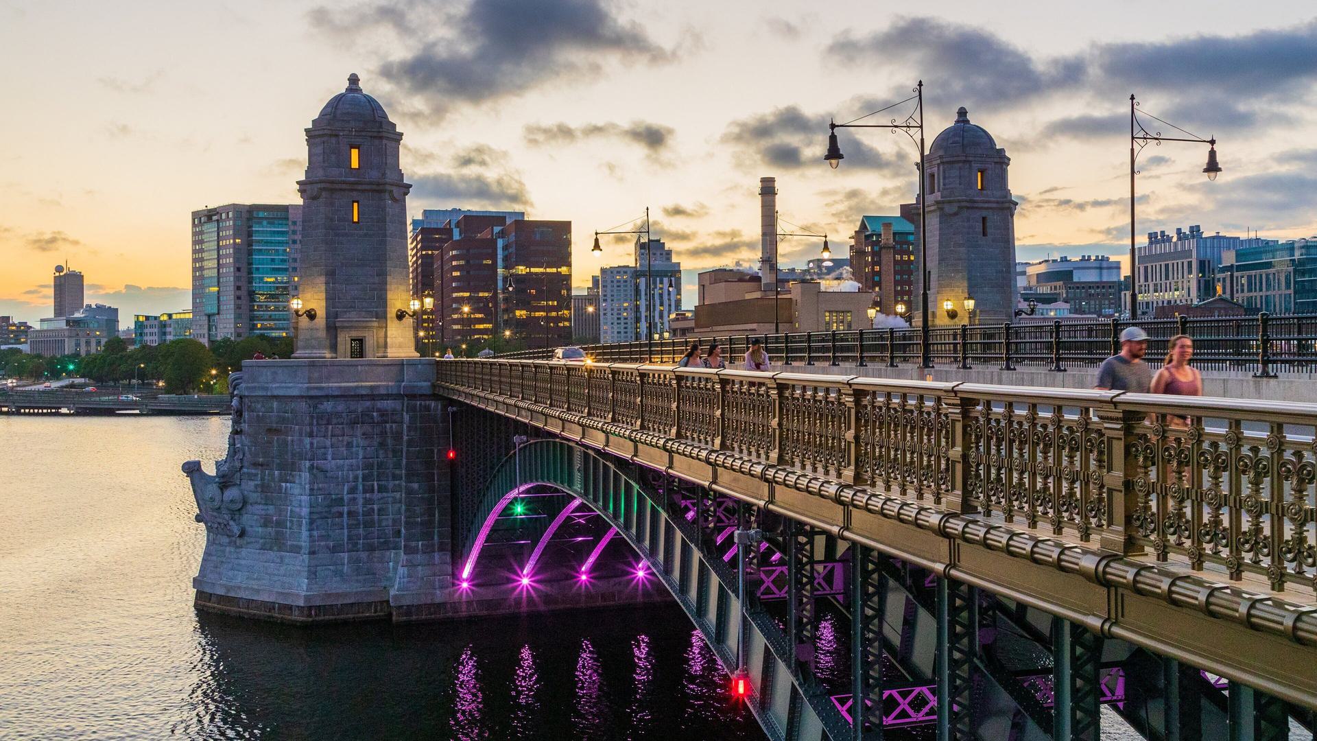 a bridge over water with a skyline in the background