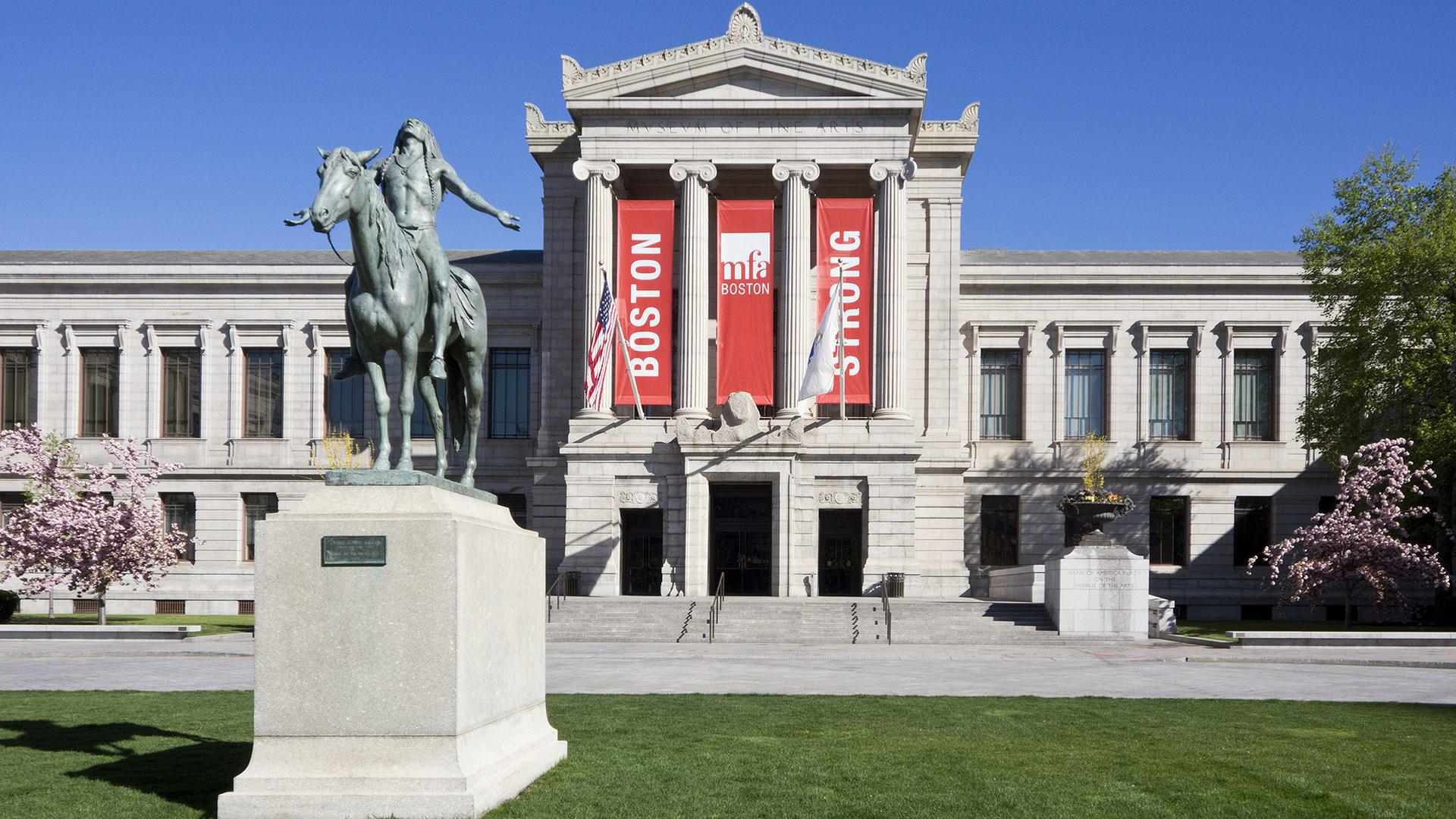 the front of a museum with a statue out front