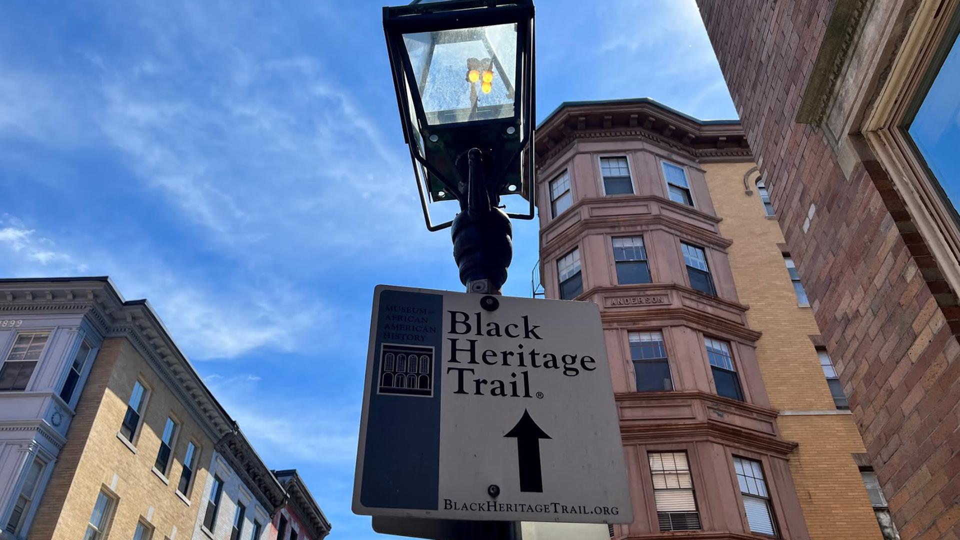 a lamppost with a sign saying "black Heritage Trail"