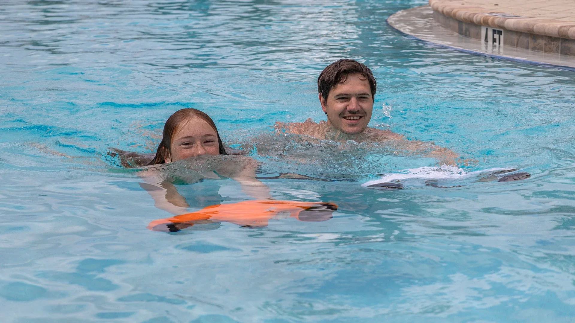 two swimmers in a pool using underwater scooters
