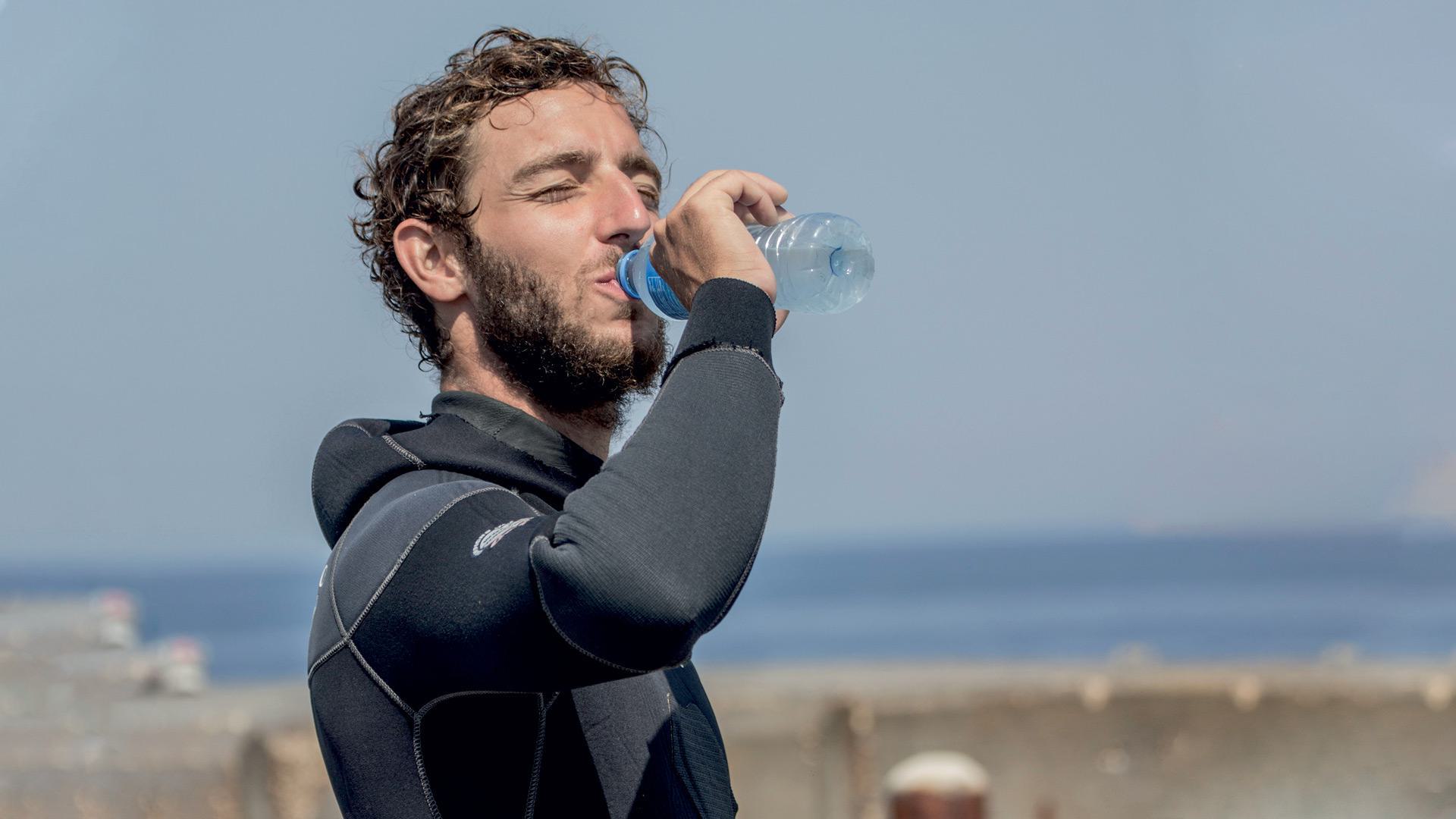 man in scuba gear drinking water