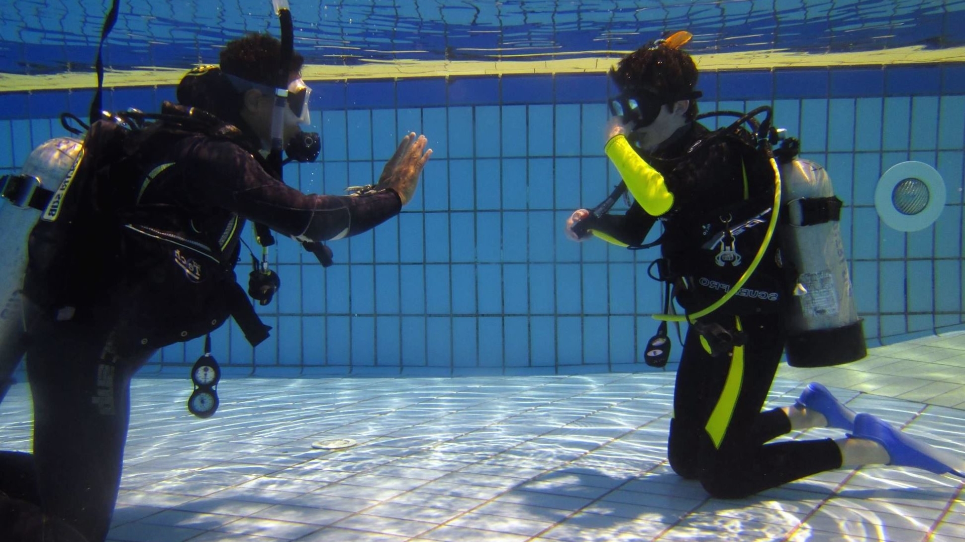 Photo of scuba instructor working with student in pool.