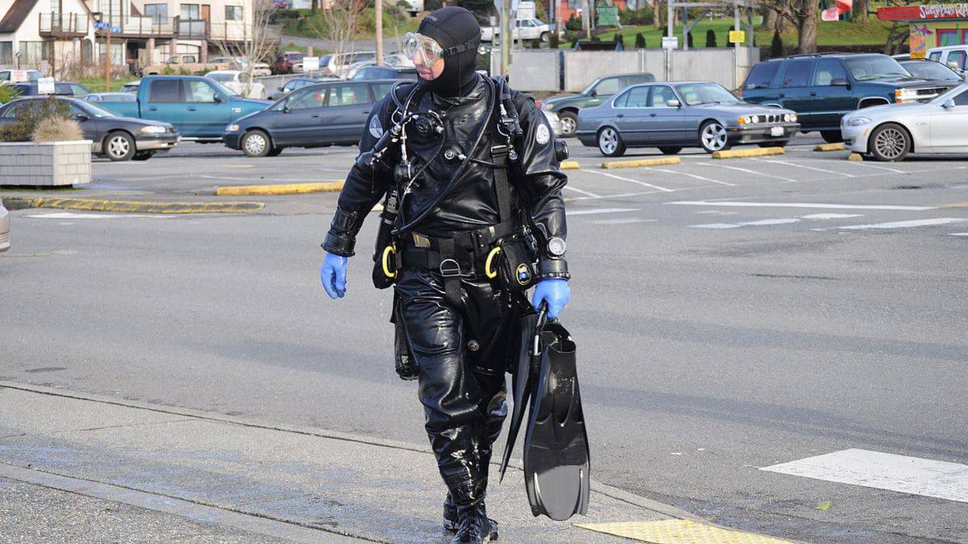a scuba diver walking in a suit in a parking lot