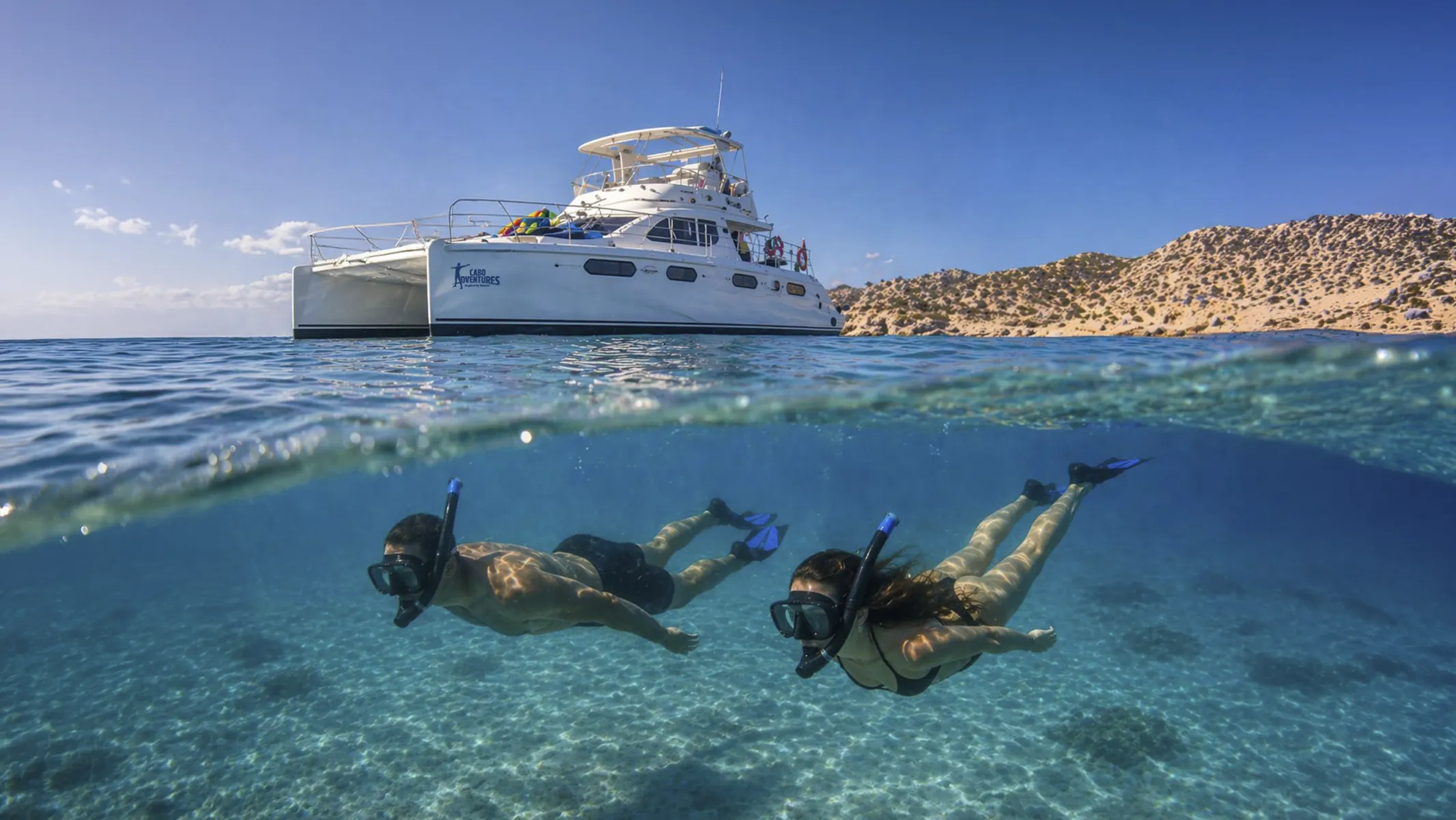 Two divers underwater next to a liveaboard
