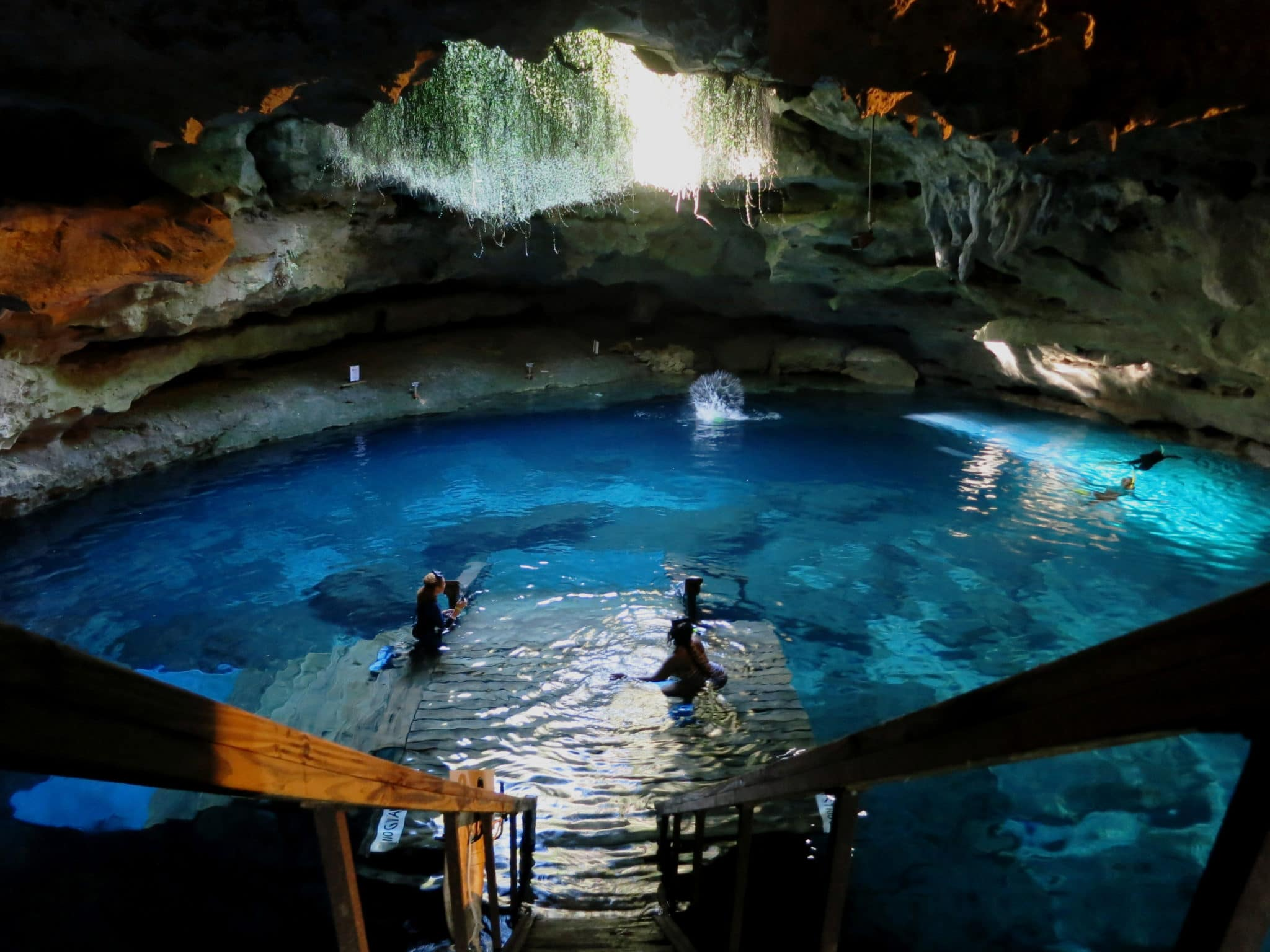 people swimming in an underground cave