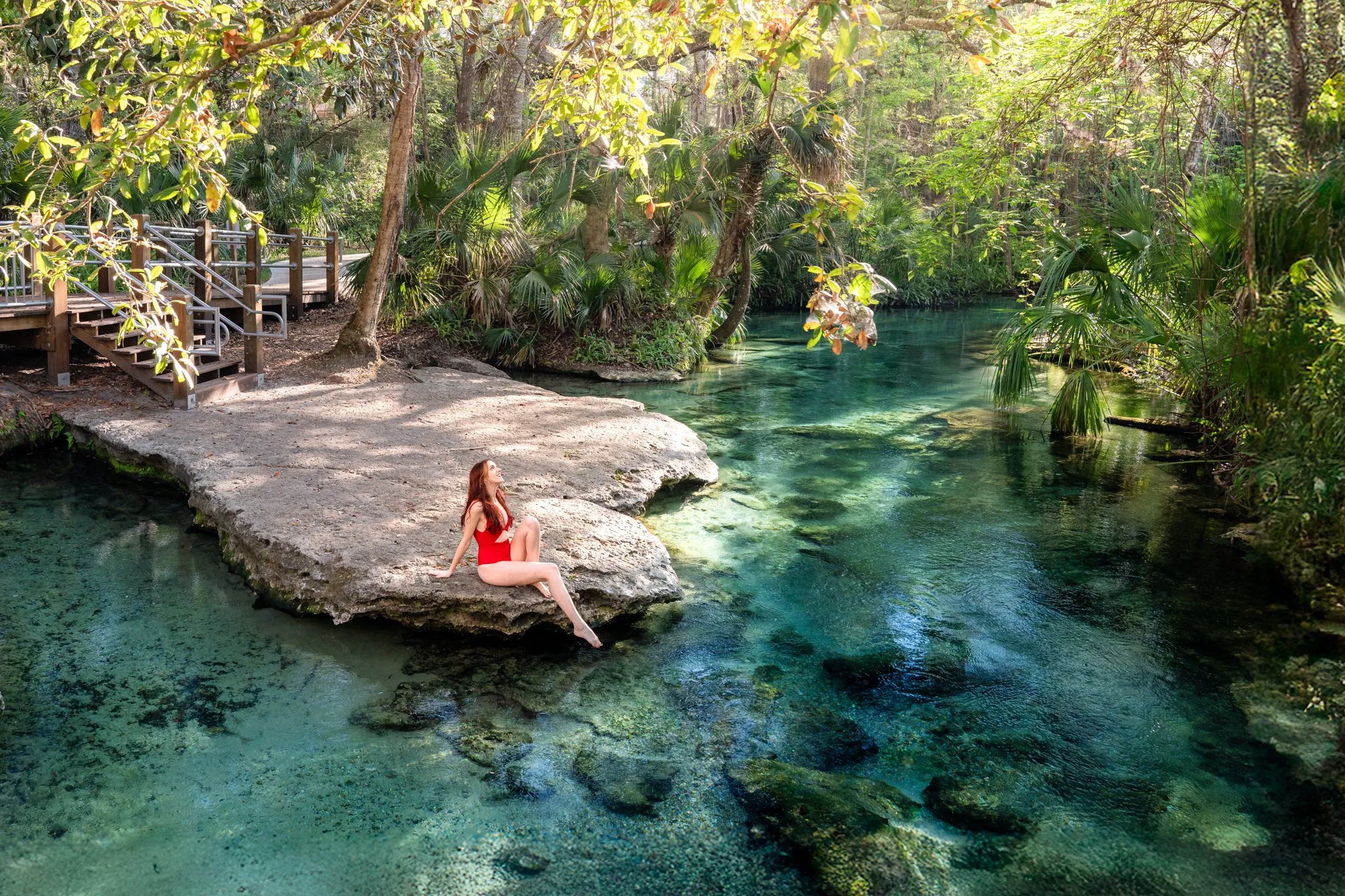 a person sitting on a rock ledge with water underneath